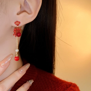 Close-up of red and gold earring featuring 福 character and RICH text with pearls