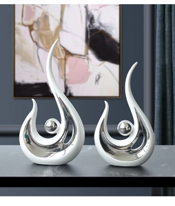Detail of modern white and silver ceramic statues on a luxury marble surface