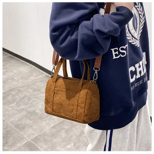 Detailed view of brown corduroy Boston bag with adjustable fabric shoulder strap