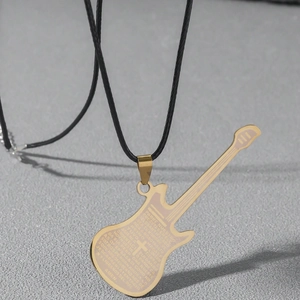 Detailed view of a golden guitar pendant with engraved cross and Spanish prayer text