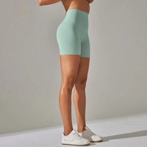 Close-up of mint green high-waisted yoga shorts with wide waistband for tummy control