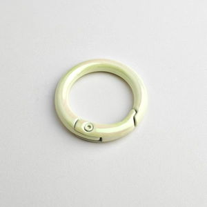 Macro detail of a light green iridescent spring O-ring buckle for DIY jewelry and keychains