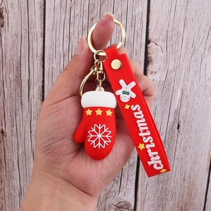 Detailed close-up of a red PVC Christmas glove keychain with golden metal hardware components