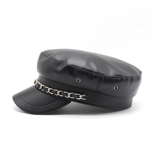 Detail of black PU leather baker boy hat with silver chain and metal eyelets