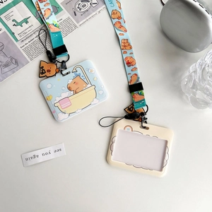 Detail of light blue Capybara card holder set with matching printed neck lanyard on desk