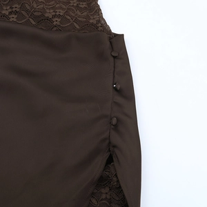 Détail d'une robe en satin marron foncé avec dentelle et boutons recouverts