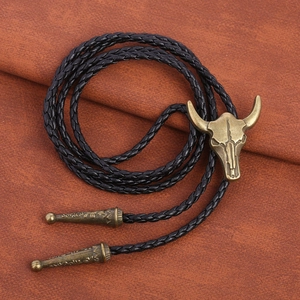 Western cowboy bull skull bolo tie with black braided leather cord and bronze metal buckle
