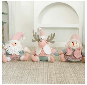 Détail de gnomes de Noël roses et gris en tricot sur un tapis beige à texture douce