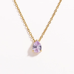 Macro shot of gold necklace with a pear-cut light purple gemstone teardrop pendant