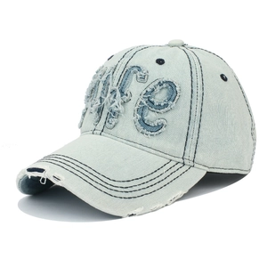 Détail d'une casquette en jean bleu clair avec patch de lettres Life effet usé