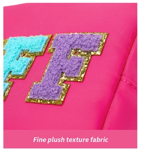 Détail de la trousse rose avec lettres en peluche bleues et mauves et bordure dorée pailletée