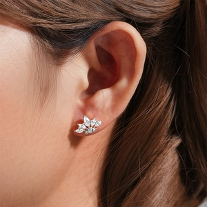 Close-up of a silver floral cartilage earring with crystal studs on a model ear