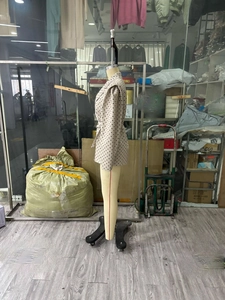 Détail d'un blazer à pois abricot avec ceinture à la taille sur un mannequin