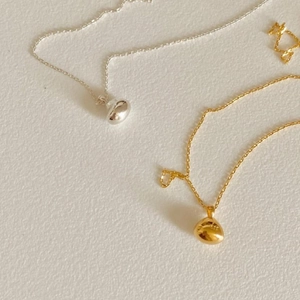 Detailed close-up of organic bean pendants in silver and gold with S925 hallmarks