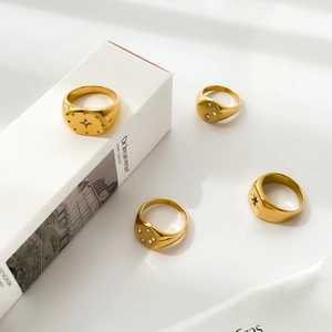 Golden star signet rings with zircon inlay set on minimalist white display background
