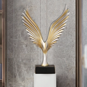 Modern minimalist resin angel wings sculpture in gold and silver on a black base