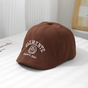 Détail du béret en coton marron foncé avec broderie smiley blanche et texte brodé