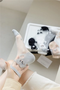 Detail view of sheer grey socks with cute cartoon animal patterns and breathable mesh fabric