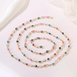 Macro shot of colorful evil eye beads and pearls on a gold link necklace detail
