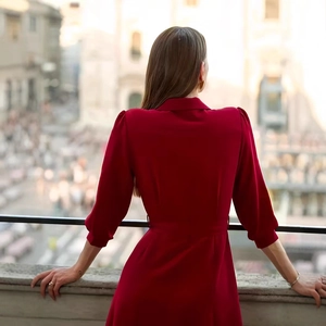 Rear view of elegant burgundy shirt dress with puff sleeves and tie waist in urban setting