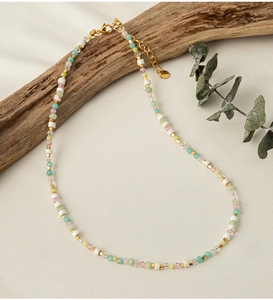Detailed shot of handmade colorful bead necklace with natural stones and gold lobster clasp
