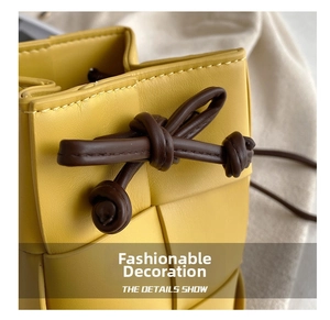 Detailed close-up of yellow woven leather bucket bag with brown drawstring and knot detail