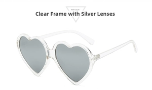 Detail view of heart-shaped sunglasses featuring a transparent frame and silver mirror lenses