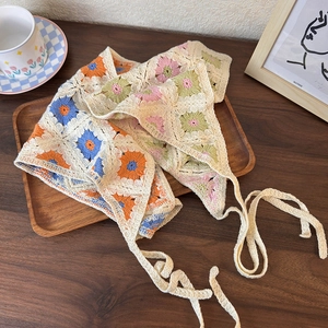 Close-up of handmade crochet triangle headscarf with intricate floral hollow patterns