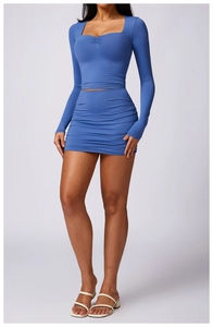 Detail of high waist ruched bodycon skirt with pleated square neck long sleeve top in blue