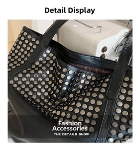 Detailed close-up showing silver rivets on the black leather tote bag with smooth texture