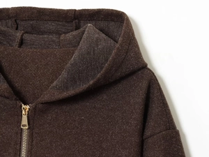 Detail of dark brown hooded jacket with premium golden metal zipper and fleece texture