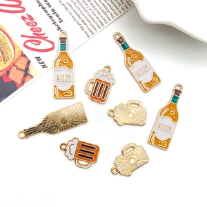 Detailed flat lay of enamel beer bottle and mug pendants for DIY jewelry making