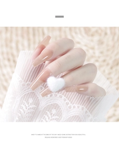 Close-up of nude matte press-on nails featuring a 3D white plush heart and lace detail