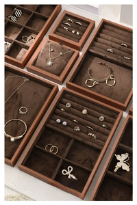 Detailed top view of brown velvet jewelry trays with compartments for rings and necklaces