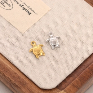 Macro view of gold and silver sea turtle pendants with geometric shell patterns