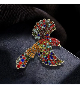 Detailed close-up of bird brooch with colorful rhinestones on a gold-plated base
