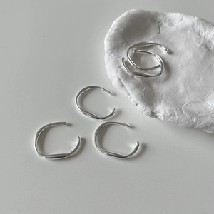 Detailed view of minimalist 925 silver irregular streamline open rings on stone base