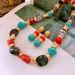Vintage bohemian jewelry set with turquoise, red stones, and golden textured beads