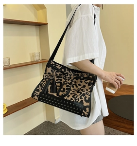 Close-up of leopard print shoulder bag with black leather trim and tassel detail