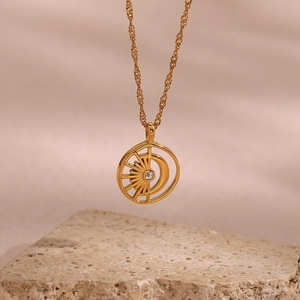 Detail view of 18K gold-plated sun and moon pendant with a white zircon on rough stone