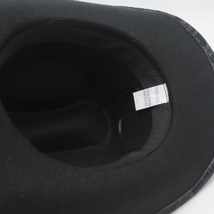 Internal detail of a black cowboy hat showing 100% polyester label and sweatband