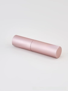 Macro detail of portable rose gold metallic perfume atomizer bottle with matte finish