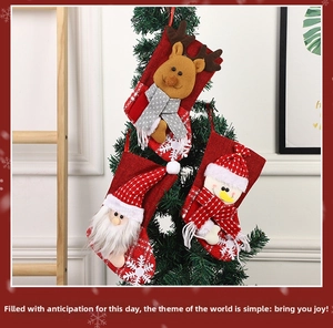 Detail of Christmas stocking trio with Santa, reindeer and snowman hanging on a tree