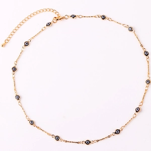 Close-up of gold-plated chain with black and white evil eye beads and adjustable clasp