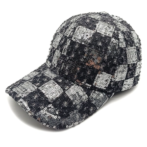 Detail of sequin checkerboard pattern and distressed frayed edges on a denim baseball cap