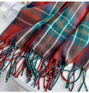Detail shot of classic plaid pattern and soft tassel texture on a thick winter scarf