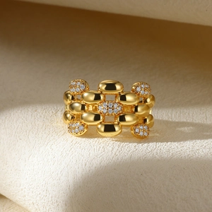 Macro shot of gold-plated wide band ring featuring rows of polished beads and cubic zirconia