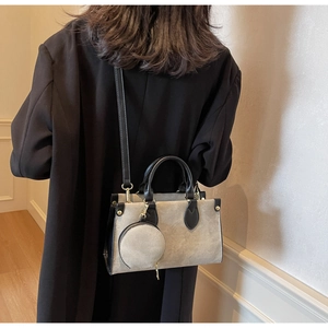 Detail of contrast stitching tote bag with small round coin purse and crossbody strap