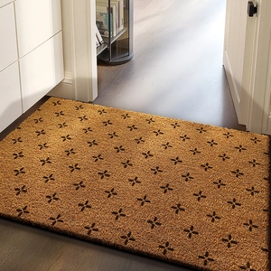 Detail of coconut fiber door mat with black cross pattern on indoor wooden floor
