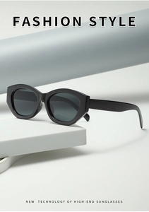Detail view of black cat-eye sunglasses on geometric white props with minimalist grey background